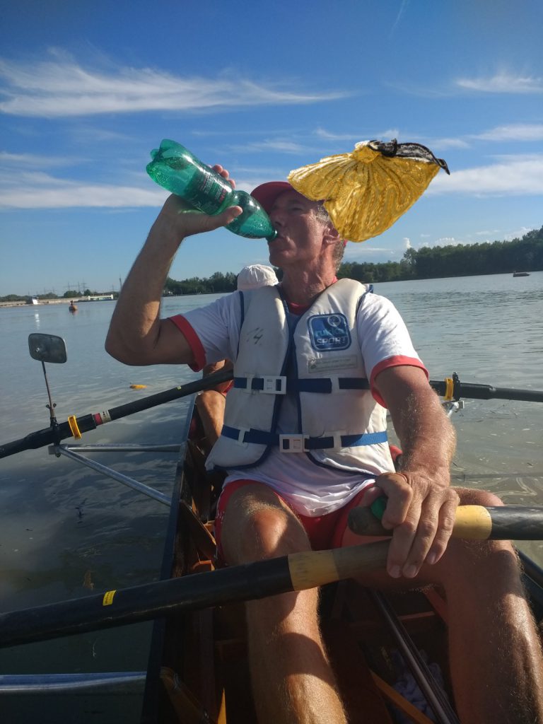 Mann in Boot mit Mineralwasserflasche und Goldhaube