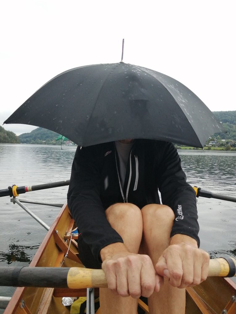 Mann mit Schirm überm Kopf